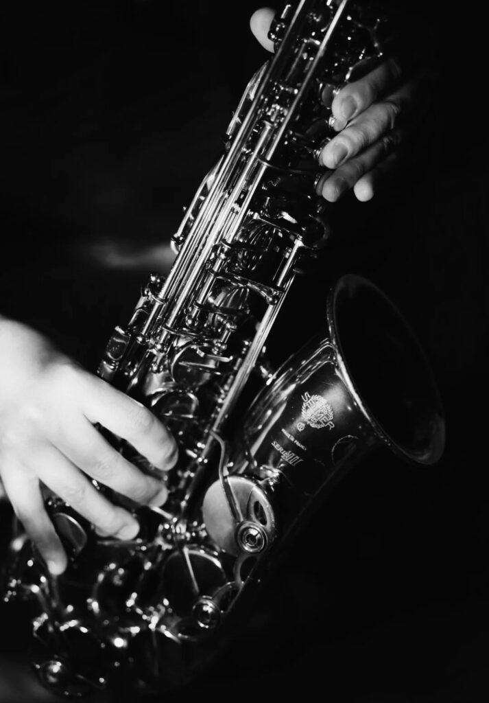 Schwarz-Weiß-Aufnahme von Händen auf einem Saxophon