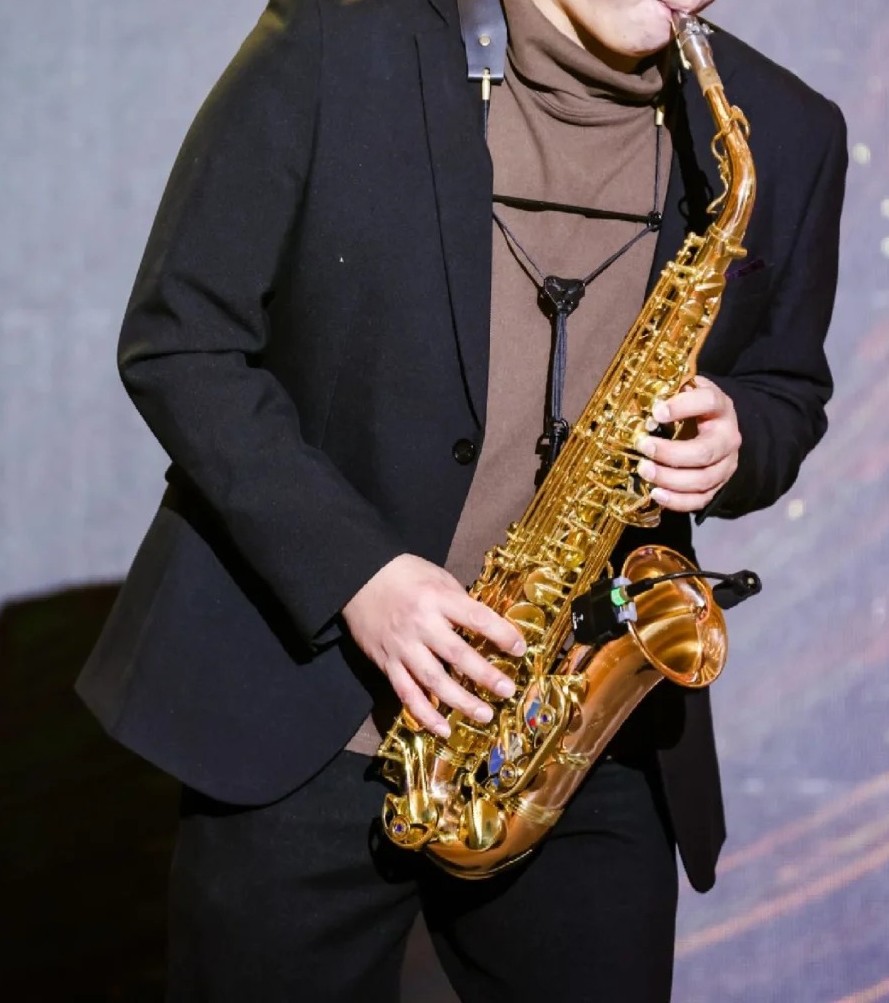 Person spielt ein Alt-Saxophon mit einem Tragegurt